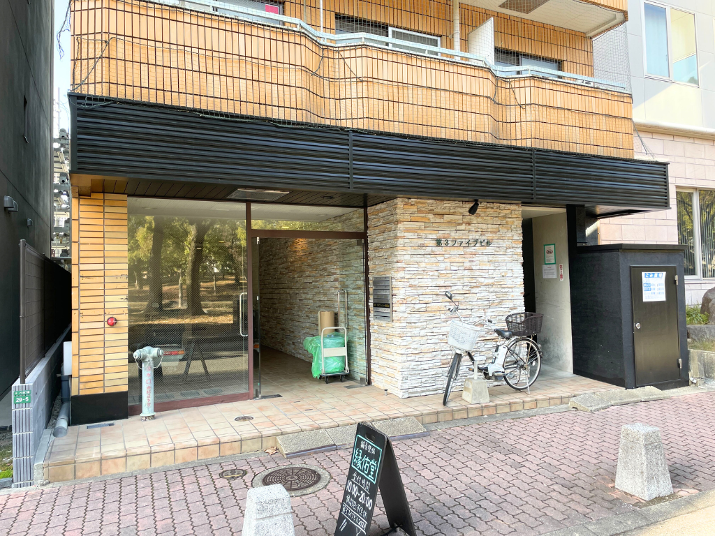 写真、つなぐ県庁前店の入口の写真です。地下鉄千代県庁口駅7番出口から歩いて3分です