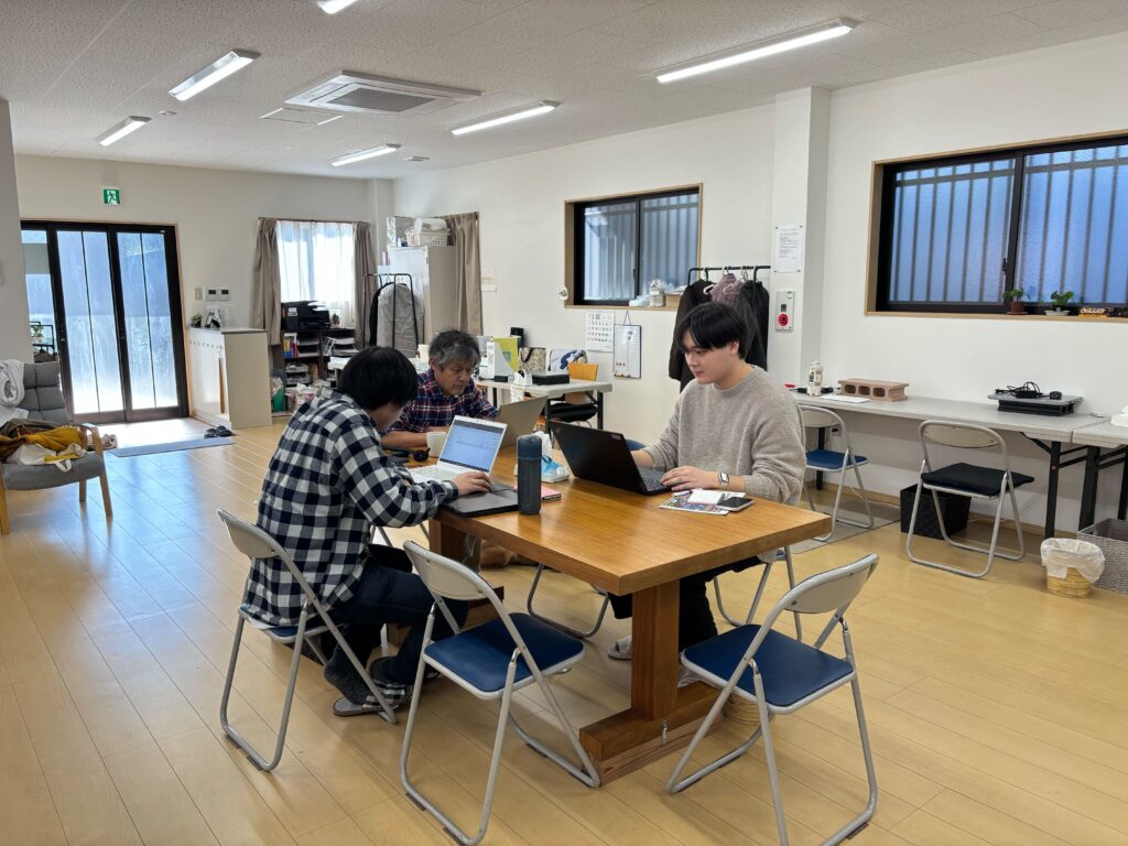 写真、中央の大机でWEBサイト制作のミーティング